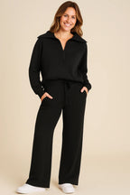 Tvådelat set för dam med halvlång dragkedja och vida byxor