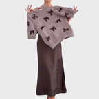 Stickad damsweater med dekorativa rosetter och kort ärm