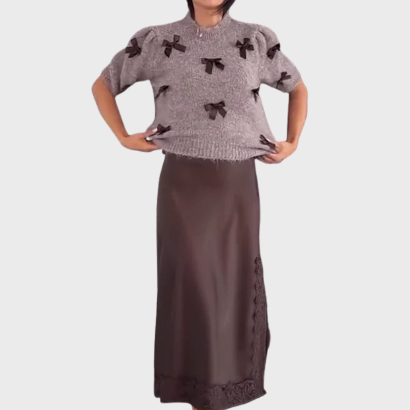 Stickad damsweater med dekorativa rosetter och kort ärm